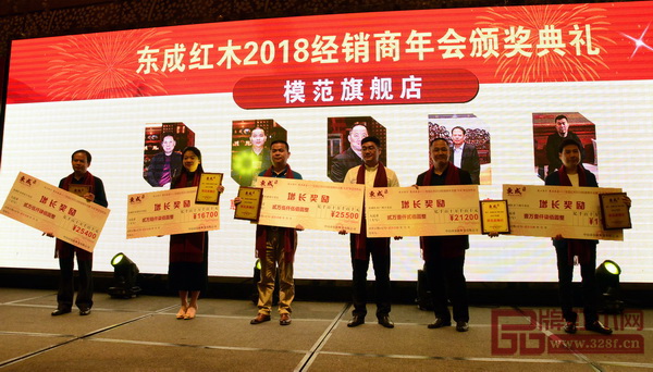 东成红木营销副总经理曾东阳（右三）为获得“模范旗舰店”的经销商颁奖